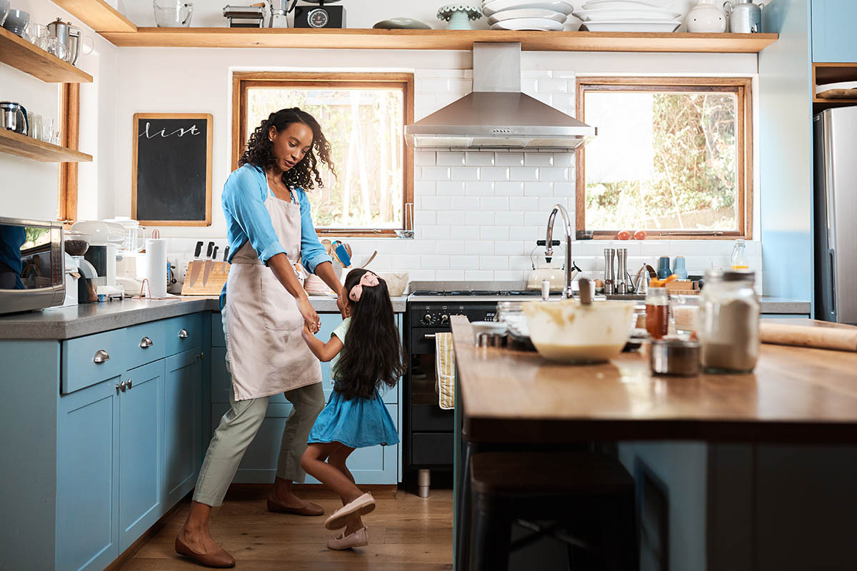 Shot of a young woman dancing with her daughter in the kitchen at home
