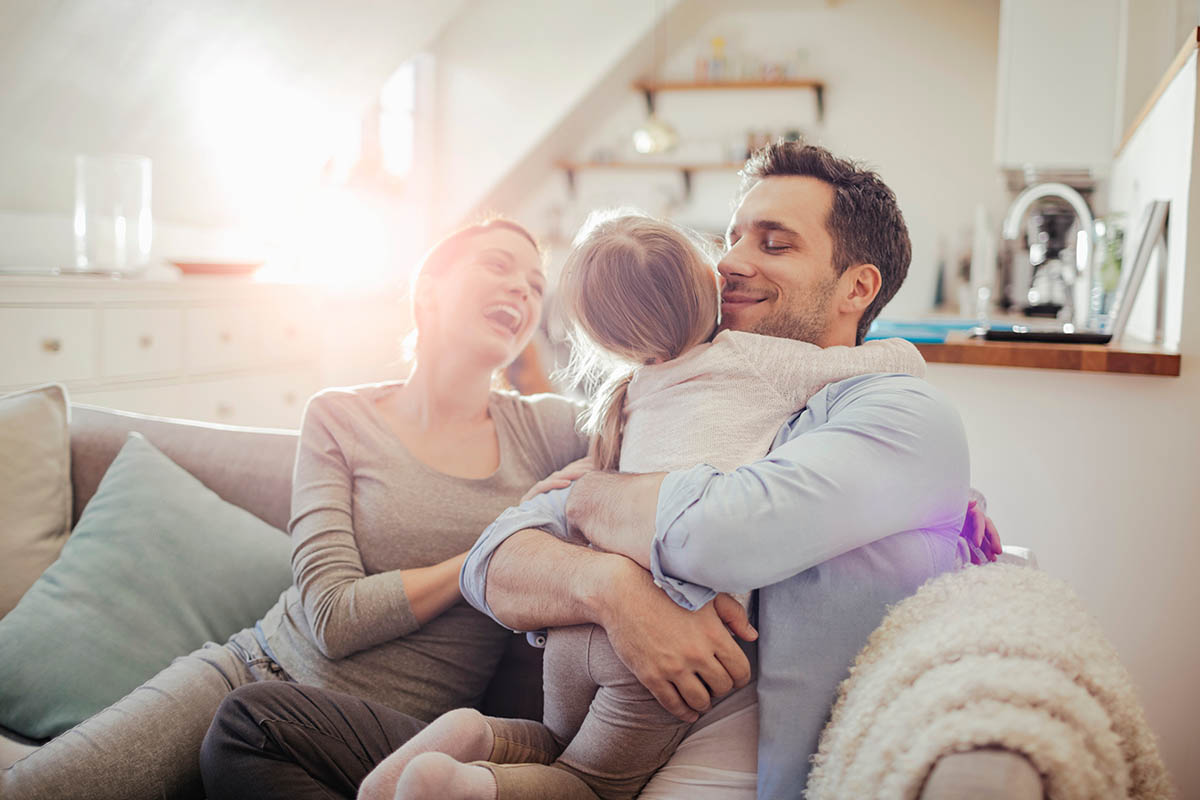 Happy young family relaxing on the couch at home